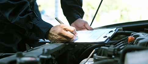 Technician noting down a vehicle inspection