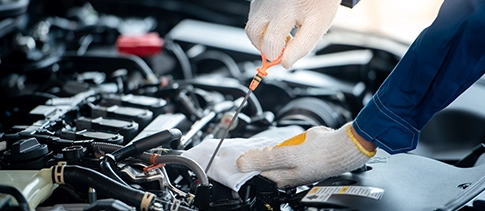 Technician checking engine oil during a service